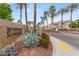 Entrance to Jasmine Ranch with lush landscaping and mature palm trees at 5855 Valley Dr # 1080, North Las Vegas, NV 89031