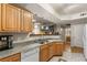 Functional kitchen with wooden cabinets, breakfast bar, and tile flooring at 5855 Valley Dr # 1080, North Las Vegas, NV 89031