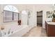 Bright bathroom featuring a soaking tub, glass shower, and a walk-in closet at 6153 Sea Cliff Cove St, North Las Vegas, NV 89031