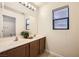 Bright bathroom with double sinks, a large mirror, and a plant for a fresh touch at 6153 Sea Cliff Cove St, North Las Vegas, NV 89031