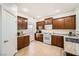 Well-lit kitchen features brown cabinetry, granite countertops, white appliances, and access to the backyard at 6153 Sea Cliff Cove St, North Las Vegas, NV 89031