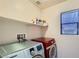 Efficient laundry room with modern washer and dryer, and storage shelf above at 6153 Sea Cliff Cove St, North Las Vegas, NV 89031
