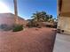 Desert landscaped backyard with privacy wall, plants, and red rock ground cover at 6475 Benbrook Springs Dr, Las Vegas, NV 89131