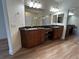 Bright bathroom featuring dual sinks, wooden cabinets, a vanity area, and a large mirror at 6475 Benbrook Springs Dr, Las Vegas, NV 89131