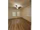 Bright bedroom features two arched windows with blinds and hardwood flooring at 6475 Benbrook Springs Dr, Las Vegas, NV 89131