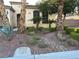 Inviting front exterior featuring desert landscaping with mature plantings, rocks, manicured bushes, and a stone path at 6475 Benbrook Springs Dr, Las Vegas, NV 89131