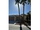Charming single-story home showcasing desert landscaping, a three-car garage, and tiled roof, accented by mature palm trees at 6475 Benbrook Springs Dr, Las Vegas, NV 89131