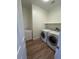 Laundry room with side by side washer and dryer, sink, and wood-look flooring at 6475 Benbrook Springs Dr, Las Vegas, NV 89131