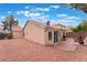 Exterior view of a single-story home with a backyard featuring a patio and desert landscaping at 6654 Coronado Crest Ave, Las Vegas, NV 89139