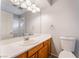 Bathroom with wood vanity, white countertop and shower with glass door at 6654 Coronado Crest Ave, Las Vegas, NV 89139