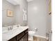 A neutral-toned powder room with a dark wood vanity, a modern sink, and sleek fixtures at 7115 Calvert Cliffs St, North Las Vegas, NV 89084