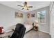 A simple bedroom with a desk area, a ceiling fan, and natural light at 7115 Calvert Cliffs St, North Las Vegas, NV 89084