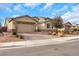 Single-story home showcasing desert landscaping, a brick driveway, and a warm-toned exterior at 7115 Calvert Cliffs St, North Las Vegas, NV 89084