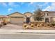 Charming single-story home featuring a desert landscape, brick driveway, and neutral stucco exterior at 7115 Calvert Cliffs St, North Las Vegas, NV 89084