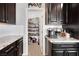 Kitchen featuring elegant dark cabinets, granite countertops, and open pantry at 7115 Calvert Cliffs St, North Las Vegas, NV 89084