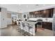 Bright kitchen featuring dark cabinets, granite countertops, stainless steel appliances, and an island with barstool seating at 7115 Calvert Cliffs St, North Las Vegas, NV 89084