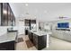 Open kitchen featuring dark cabinetry, granite countertops, stainless steel appliances, and a convenient island at 7115 Calvert Cliffs St, North Las Vegas, NV 89084