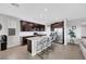 Modern kitchen with dark cabinets, stainless steel appliances, granite counters, and a center island with seating at 7115 Calvert Cliffs St, North Las Vegas, NV 89084