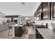 Open-concept kitchen with island, dark cabinets, granite countertops and stainless steel appliances at 7115 Calvert Cliffs St, North Las Vegas, NV 89084