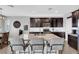 Spacious kitchen with dark wood cabinets, granite countertops, stainless steel appliances, and bar stool seating at 7115 Calvert Cliffs St, North Las Vegas, NV 89084