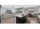 Well-lit kitchen featuring a center island with sink, stainless steel appliances, and an open layout to the living and dining areas at 7115 Calvert Cliffs St, North Las Vegas, NV 89084