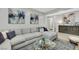 Cozy living room featuring a large gray sectional, modern decor, and bright, neutral walls at 7115 Calvert Cliffs St, North Las Vegas, NV 89084