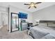 This main bedroom features a ceiling fan, television, large mirror, and a comfortable bed at 7115 Calvert Cliffs St, North Las Vegas, NV 89084