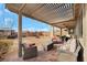 Covered patio with upscale furniture overlooks a manicured lawn, offering a relaxing outdoor living space at 7115 Calvert Cliffs St, North Las Vegas, NV 89084