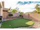 Artificial putting green in a nicely landscaped backyard with a retaining wall and brick edging at 7386 Campbell Ranch Ave, Las Vegas, NV 89179
