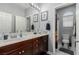 Bathroom features a wood vanity with white countertop, updated fixtures, and view of toilet room at 7386 Campbell Ranch Ave, Las Vegas, NV 89179