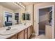 Bright bathroom featuring double sinks and ample counter space with view to main bedroom at 75 E Agate Ave # 204, Las Vegas, NV 89123