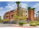 Condominium building with a landscaped yard and palm trees on a sunny day at 75 E Agate Ave # 204, Las Vegas, NV 89123