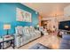 Bright living room featuring a plush white reclining sofa, wooden floors and teal accent wall with a world map at 75 E Agate Ave # 204, Las Vegas, NV 89123