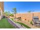 Landscaped backyard featuring a rock creek bed and desert landscaping at 797 Drammatico Pl, Henderson, NV 89011