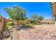 Expansive backyard featuring a brick patio, mature trees, and garden areas, perfect for outdoor living and entertaining at 797 Drammatico Pl, Henderson, NV 89011