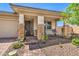 Inviting front porch featuring stone accents, desert landscaping, and decorative iron front door at 797 Drammatico Pl, Henderson, NV 89011