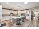 Spacious kitchen featuring stainless steel appliances, modern lighting, white cabinetry and a large center island at 797 Drammatico Pl, Henderson, NV 89011