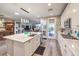 Open kitchen features an island with seating, white cabinets, stainless appliances and tile backsplash at 797 Drammatico Pl, Henderson, NV 89011