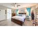 Spacious main bedroom with ensuite bathroom, a large bed, wood-look floors and natural lighting at 797 Drammatico Pl, Henderson, NV 89011