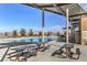 Community pool area featuring lounge chairs, picnic tables, and a covered pavilion, offering a resort-style experience at 797 Drammatico Pl, Henderson, NV 89011