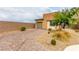 Well-manicured home exterior featuring stone and stucco, complemented by gravel and lush landscaping at 8242 Vino Merlot Ave, Las Vegas, NV 89113
