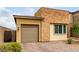 Charming home featuring a stone facade, neutral stucco, two-car garage, and paved driveway at 8242 Vino Merlot Ave, Las Vegas, NV 89113