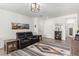 Inviting living room with modern light fixture, stylish furnishings, and wood-look tile flooring at 8242 Vino Merlot Ave, Las Vegas, NV 89113
