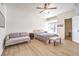 Cozy bedroom featuring a ceiling fan, wood-look flooring, and large windows for natural light at 8408 Running Deer Ave # 201, Las Vegas, NV 89145