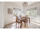 Bright dining room with wooden table, four chairs, and natural light from two windows at 8408 Running Deer Ave # 201, Las Vegas, NV 89145