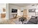 Open-concept living room with stylish decor, wood floors, and modern entertainment setup at 8408 Running Deer Ave # 201, Las Vegas, NV 89145