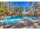 Outdoor community pool featuring a rock waterfall and surrounding tall trees at 8408 Running Deer Ave # 201, Las Vegas, NV 89145
