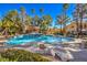 Outdoor community pool surrounded by palm trees and sunbathing areas at 8408 Running Deer Ave # 201, Las Vegas, NV 89145
