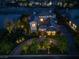 Stunning aerial view of a luxurious house, showcasing its manicured landscaping and circular driveway at night at 9533 Orient Express Ct, Las Vegas, NV 89145