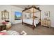 Elegant bedroom featuring a four-poster bed, wood floors, and bright natural light from a large window at 9533 Orient Express Ct, Las Vegas, NV 89145